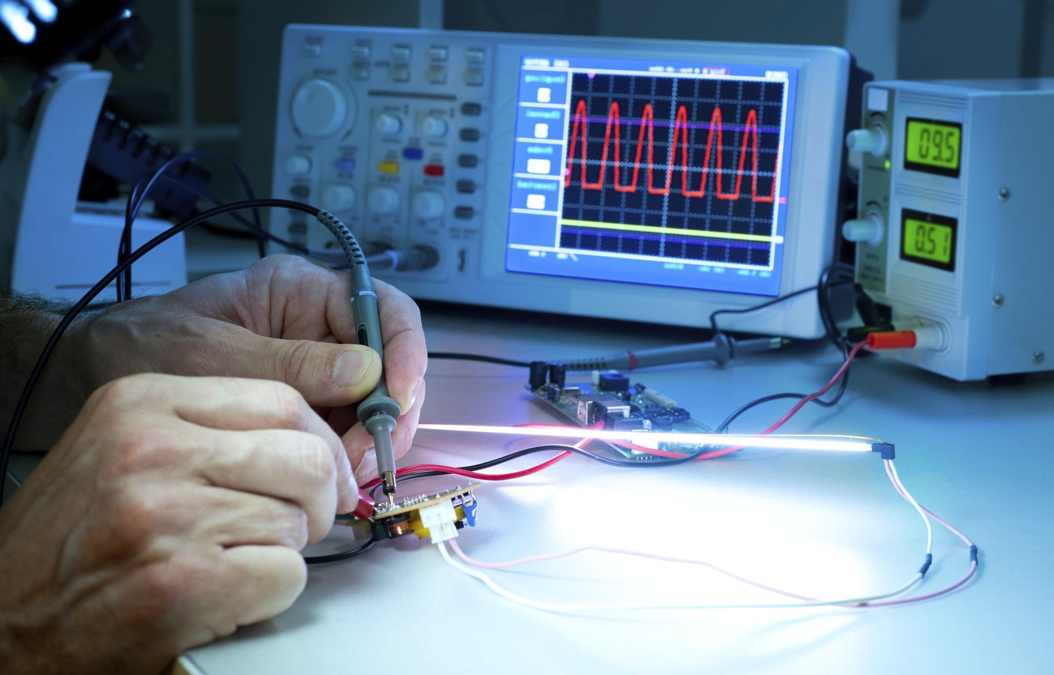 Photo de l'atelier avec poste de test et oscilloscope